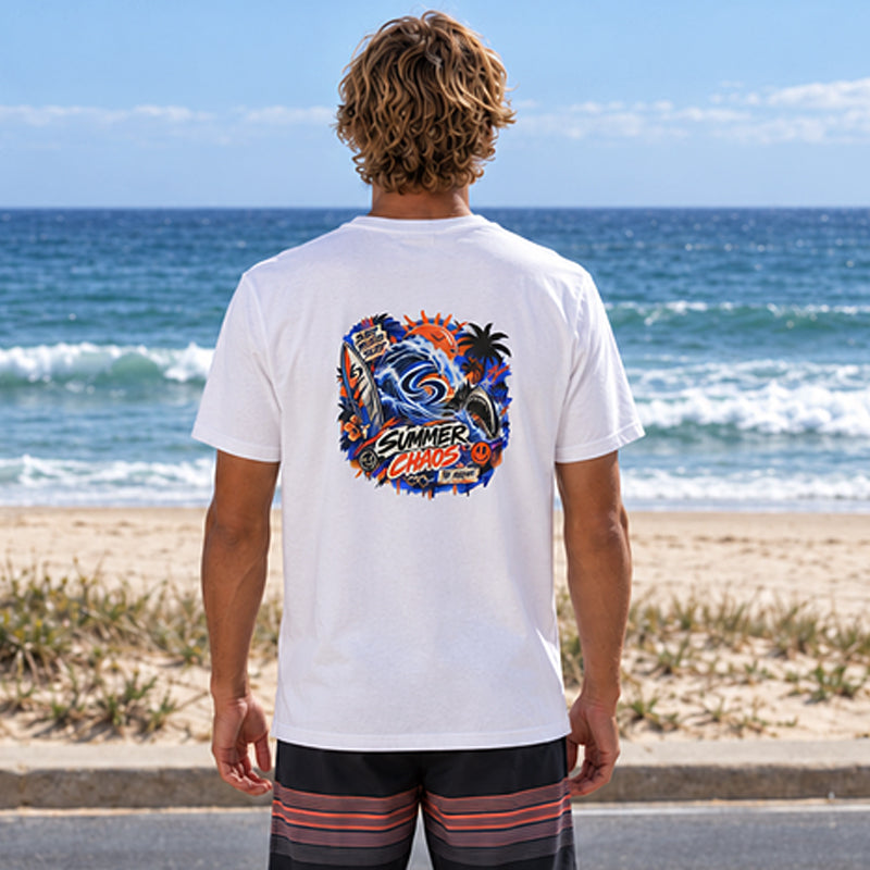Back view of the Subora Summer Chaos Tee in White on a male model looking out at the surf, showing the full-colour Summer Chaos street-art back print with wave, shark, palms and surfboard