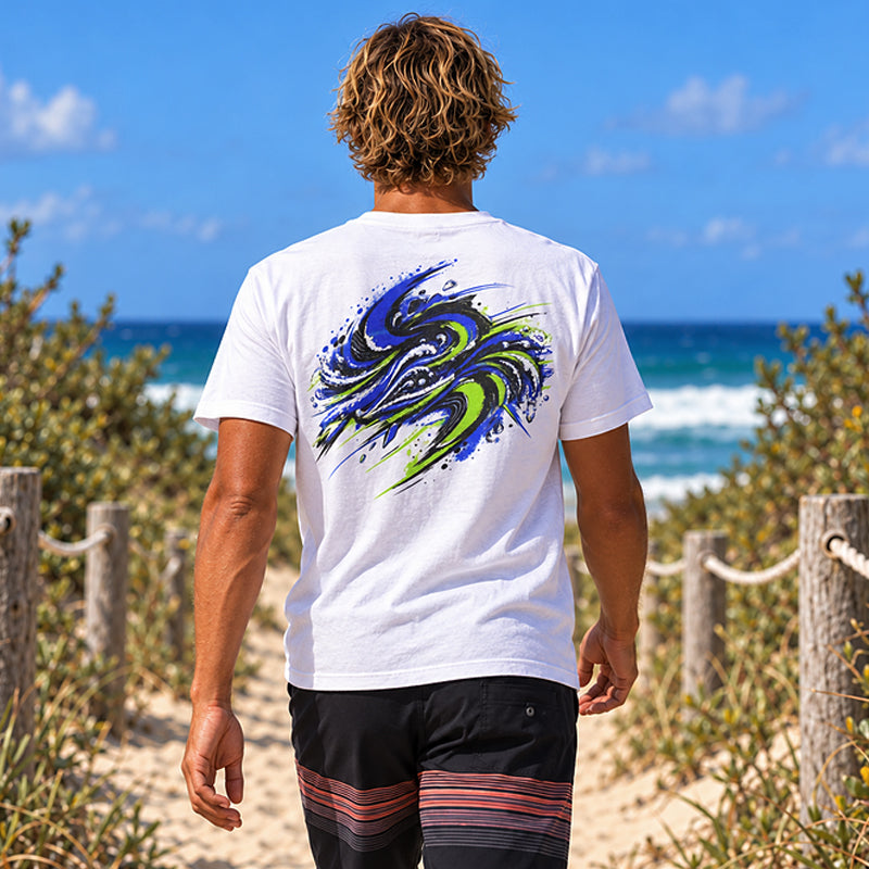 Back view of the Subora Motion Tee in White on a male model walking down a beach dune track, showing the full-colour blue and lime green swirling wave back print