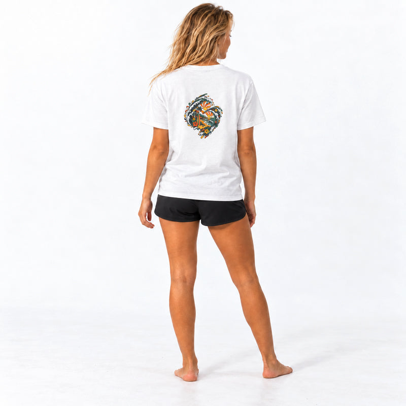 Back view of the Subora Paradise Tee in White on a female model, showing the full-colour wave back print