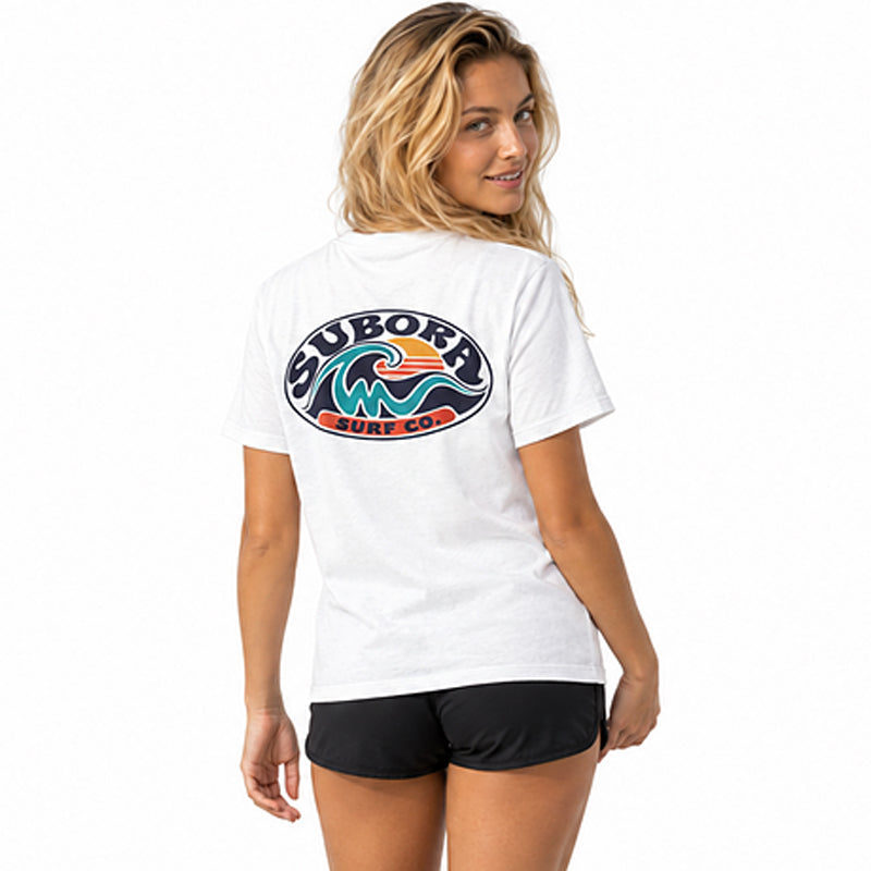 Back view of the Subora Sunwash Tee in White on a female model, showing the retro oval Subora Surf Co. badge back print with a teal wave, orange setting sun and navy lettering