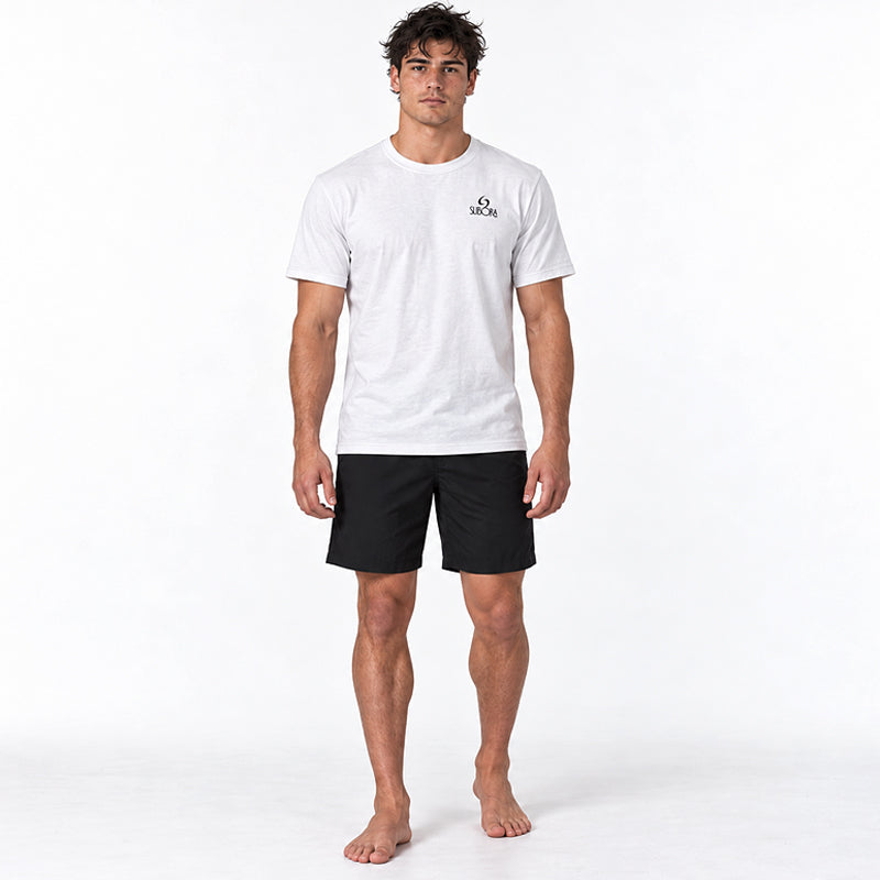 Back view of the Subora Tripp'en Tee in White on a male model, showing the hand-drawn back print of a kombi loaded with surfboards and a crew of mates driving along the coast past a Subora S wave